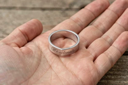 Bague coeur magnétique en argent avec gravure romantique posée dans une paume ouverte, vue macro en gros plan